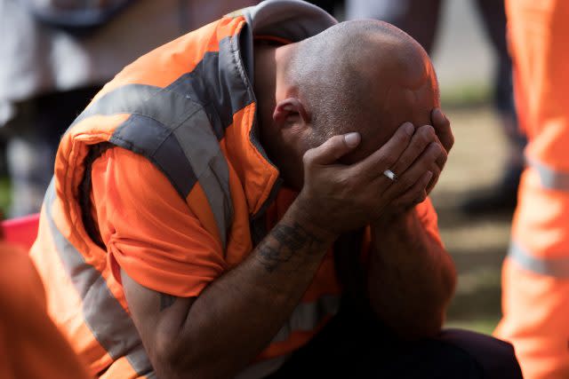 A bin worker puts head in his hands at the Perry Barr Household Recycling Centre in Birmingham after refuge collectors went back on strike following the city council's decision to begin issuing redundancy notices (Aaron Chown/PA)