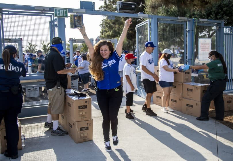 LOS ANGELES, CA - JUNE 15, 2021: Alice Maldonado of Los Angeles reacts as she enter Dodgers Stadium for its reopening night holding a bobble head of Justin Turner before the Dodgers play the Phillies on June 15, 2021 in Los Angeles, California.(Gina Ferazzi / Los Angeles Times)