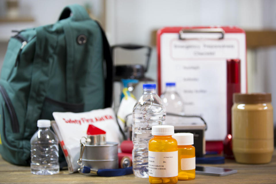 Emergency preparedness supplies, including a flashlight, backpack, batteries, water bottles, first aid kit, lantern, radio, can opener and mask.  / Credit: Getty Images/iStockphoto