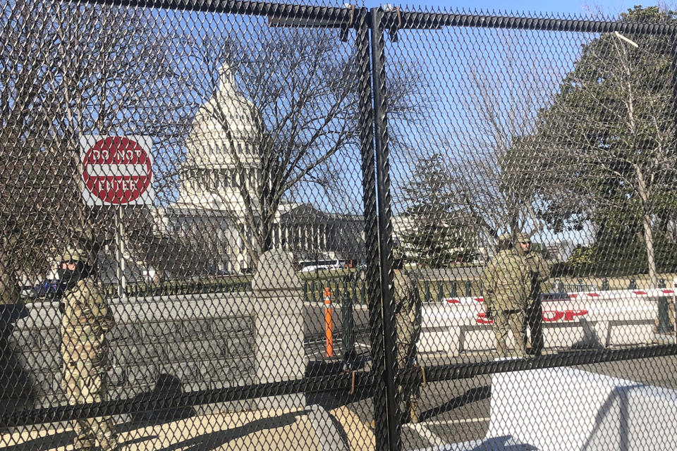 Members of the National Guard stand inside anti-scaling fencing that surrounds the Capitol, Sunday, Jan. 10, 2021, in Washington. Last week’s mob attack on the U.S. Capitol starkly highlighted a longstanding local security paradox: The District of Columbia government lacks authority over much of the area within its borders. (AP Photo/Alan Fram)