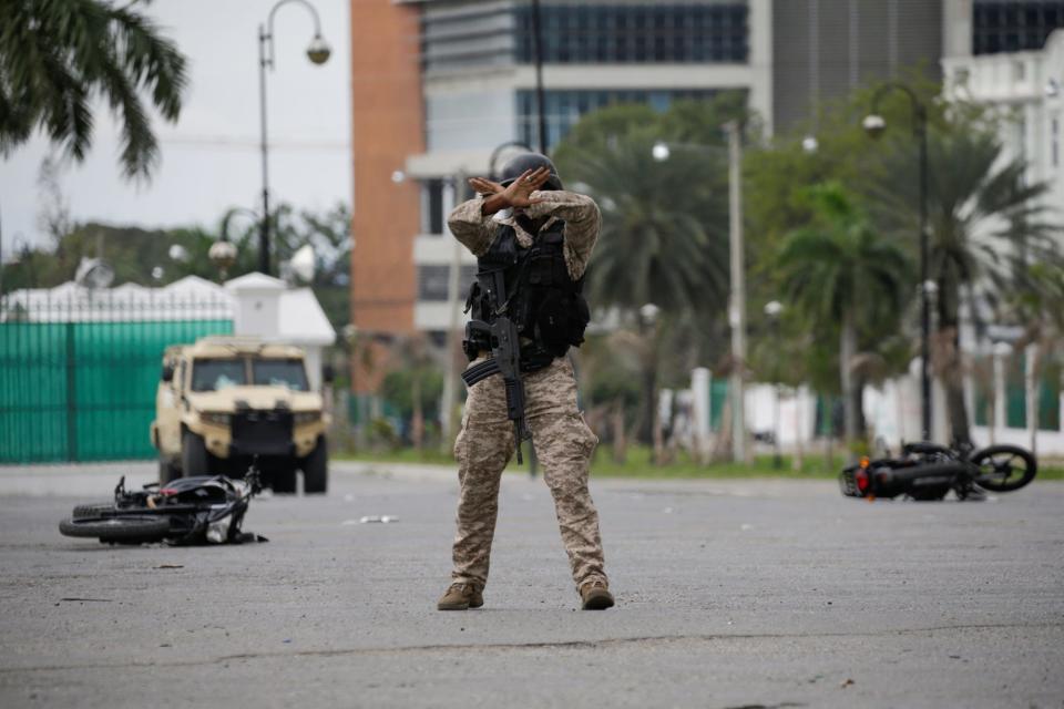 A Haitian National Police officer gestures to calm down protesters during a shooting in Champ de Mars, Port-au-Prince, Haiti February 23, 2020.