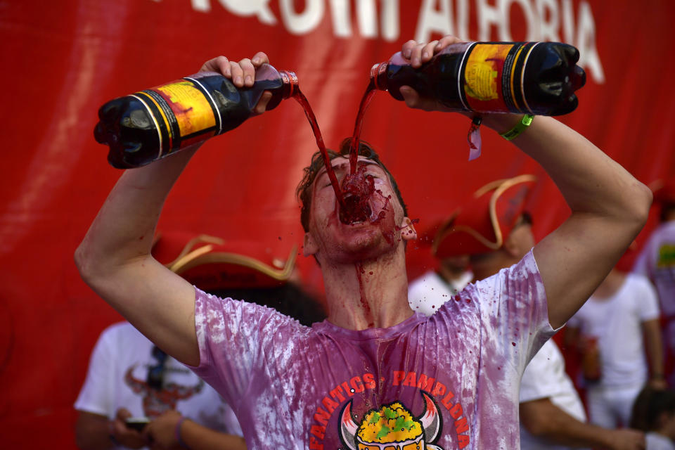 Revellers drink wine as they start celebrating early while waiting for the launch of the 'Chupinazo' rocket, to celebrate the official opening of the 2019 San Fermin fiestas with daily bull runs, bullfights, music and dancing in Pamplona, Spain, July 6, 2019. (Photo: Alvaro Barrientos/AP)