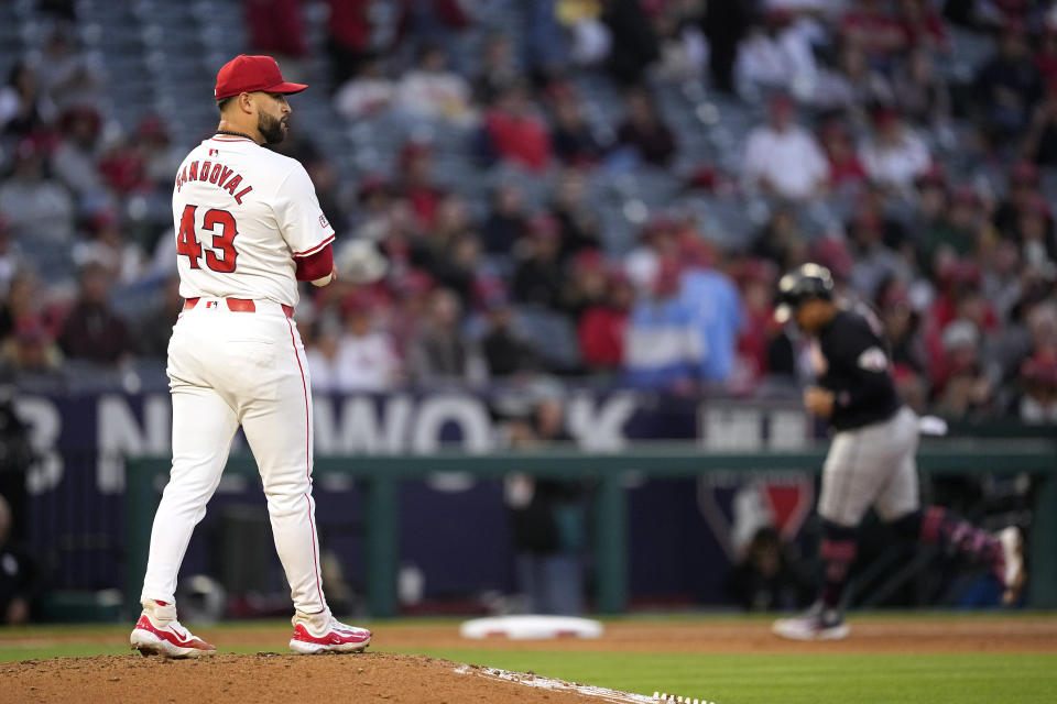 Cleveland Guardians' Josh Naylor, right, rounds third as Los Angeles Angels starting pitcher Patrick Sandoval stands on the mound during the fourth inning of a baseball game Friday, May 24, 2024, in Anaheim, Calif. (AP Photo/Mark J. Terrill)