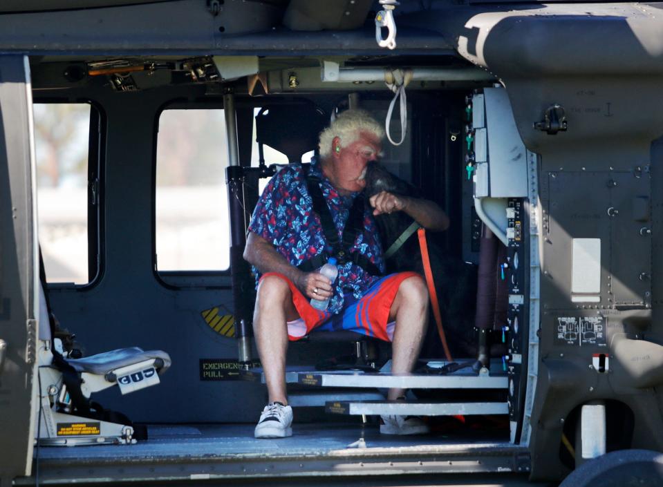 Pine Island resident Tom O'Sullivan is evacuated along with his dog "Jack" by members of a Florida Army National Guard helicopter crew out of Jacksonville. The crew assisted in the evacuation efforts stationed at Matlacha / Pine Island Fire station One, Sunday October 02, 2022.