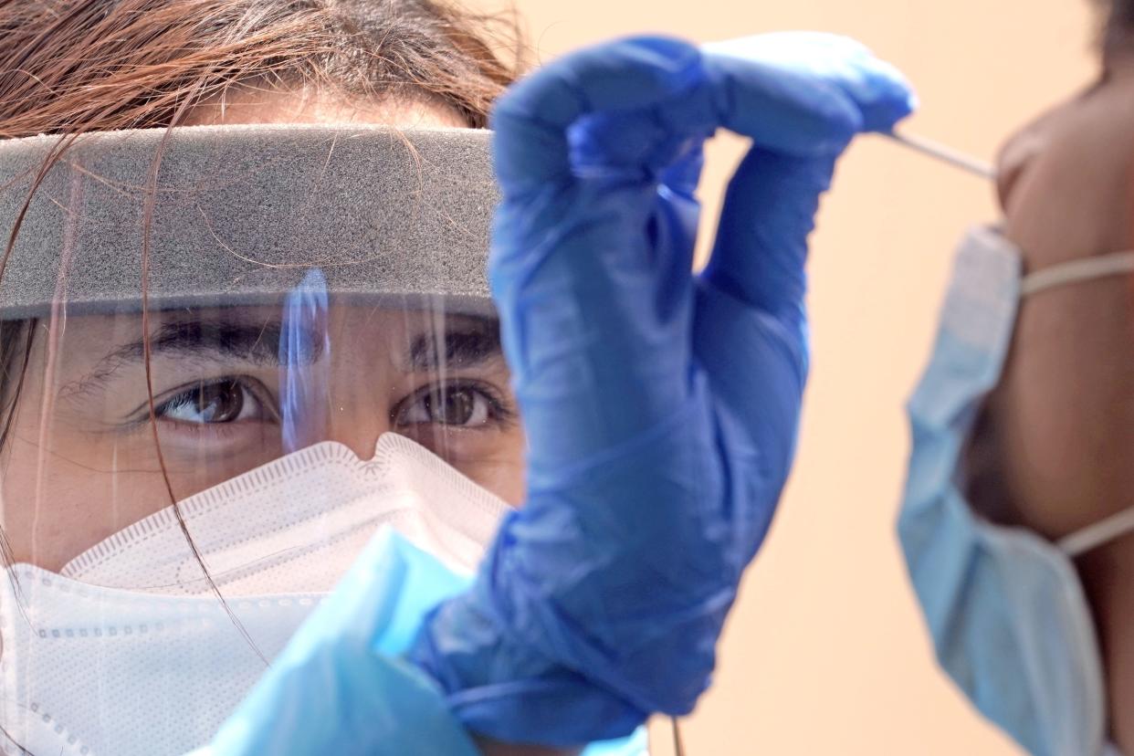 Medical student Kimberly Olivares, left, takes a sample from a patient at a free COVID-19 testing site provided by United Memorial Medical Center on June 28, 2020 at the Mexican Consulate in Houston. On Friday, Texas Gov. Greg Abbott shut down bars again and scaled back restaurant dining as cases climbed to record levels after the state embarked on one of America's fastest reopenings.