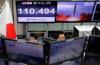 Employees of a foreign exchange trading company work in front of monitors showing TV news on North Korea's threat (R) and the Japanese yen's exchange rate against the U.S. dollar (L) in Tokyo, Japan, September 14, 2017. REUTERS/Toru Hanai