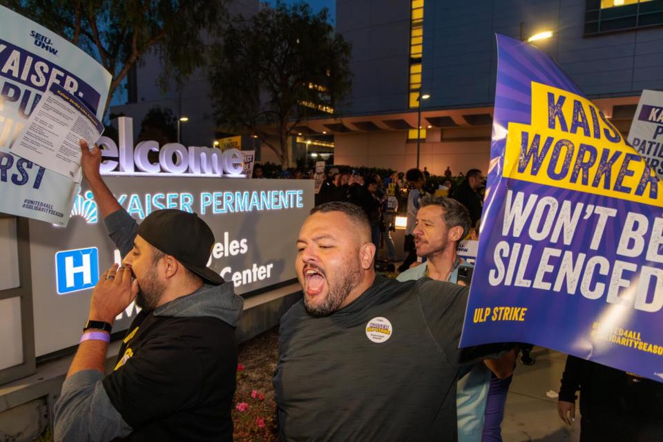 Picketers outside a hospital at night.