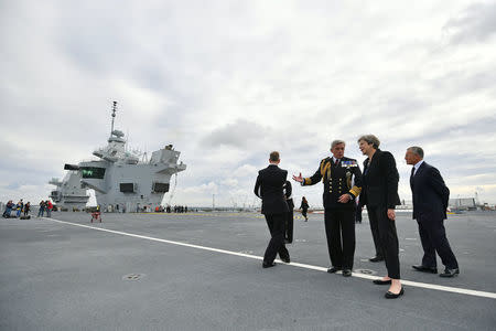 Britain's Prime Minister Theresa May talks with First Sea Lord Admiral Philip Jones on the British aircraft carrier HMS Queen Elizabeth, during her tour of the ship, after it arrived at Portsmouth Naval base, its new home port, in Portsmouth, Britain August 16, 2017. REUTERS/Ben Stansall/Pool