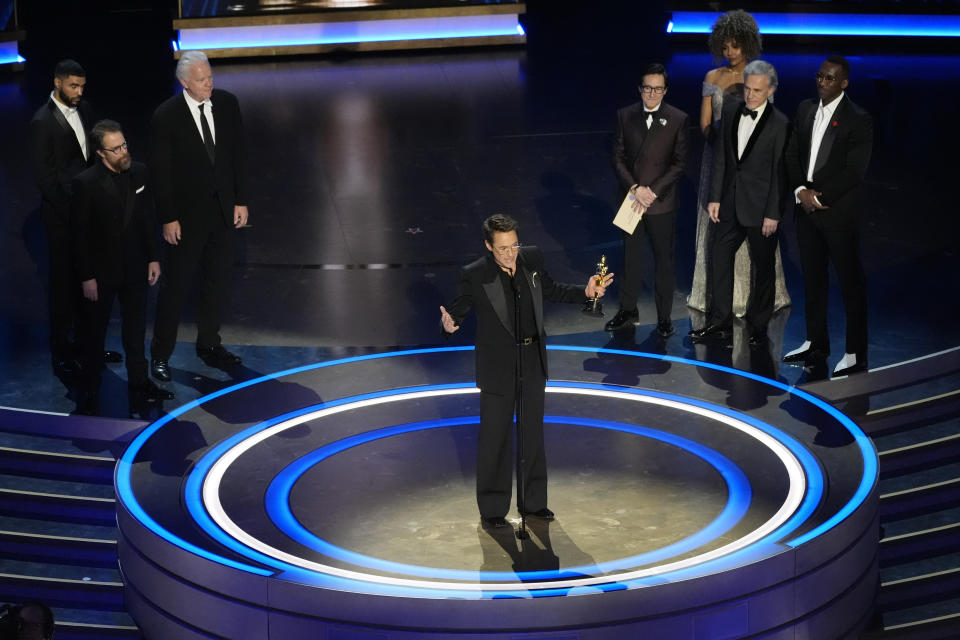 Robert Downey Jr. accepts the award for best performance by an actor in a supporting role for "Oppenheimer" during the Oscars on Sunday, March 10, 2024, at the Dolby Theatre in Los Angeles. Sam Rockwell, from left, Tim Robbins, Ke Huy Quan, Christoph Waltz, Mahershala Ali look on.(AP Photo/Chris Pizzello)