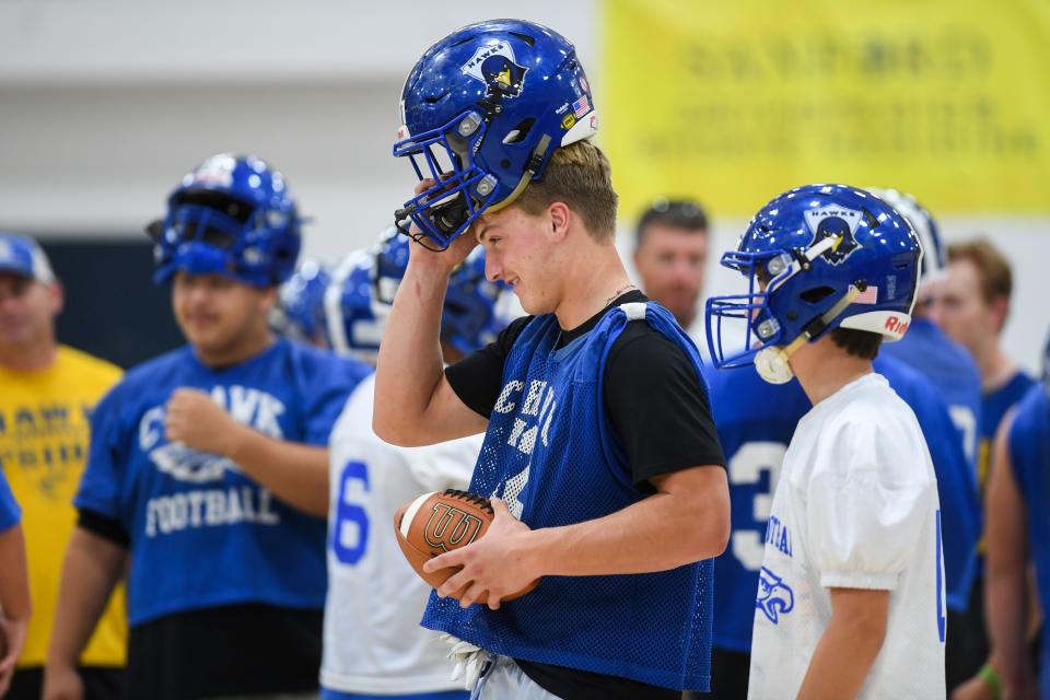 Cain Wallner (72) puts on his helmet for another drill at Canton High School in Canton, South Dakota on Tuesday, Aug. 22, 2023.