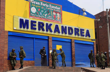 Colombian police and soldiers guard a supermarket supposedly linked to FARC in Bogota, Colombia February 21, 2018. REUTERS/Jaime Saldarriaga