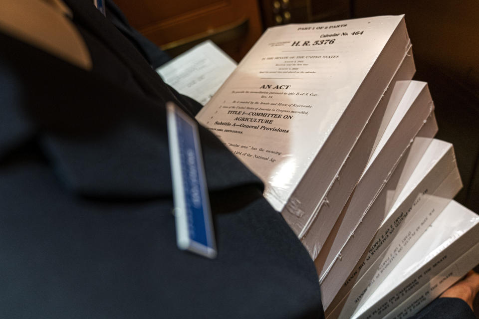 FILE - A page holds copies of the Inflation Reduction Act, inside an elevator inside the Capitol, Sept. 7, 2022, in Washington. The one-year anniversary of the Inflation Reduction Act being signed into law is on Wednesday, Aug. 16, 2023. (AP Photo/Jacquelyn Martin, File)