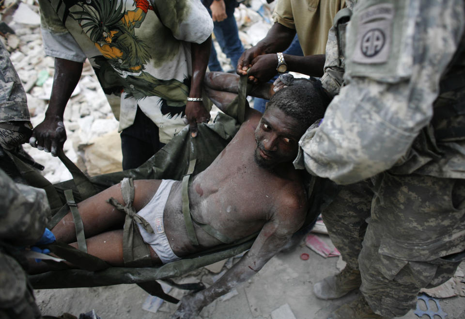 <p>Rico Dibrivell, 35, is attended by a U.S. military rescue team after being freed from the rubble of a building in Port-au-Prince, Haiti, Jan. 26, 2010. (Photo: Eduardo Munoz/Reuters) </p>