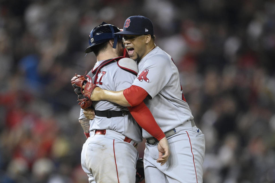 Boston Red Sox relief pitcher Hansel Robles, right, and catcher Christian Vazquez, left, celebrate after a baseball game against the Washington Nationals, Saturday, Oct. 2, 2021, in Washington. The Red Sox won 5-3.(AP Photo/Nick Wass)