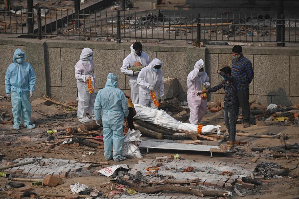 Relatives and friends, wearing PPE suits, prepare a body for cremation in New DelhiAFP via Getty Images