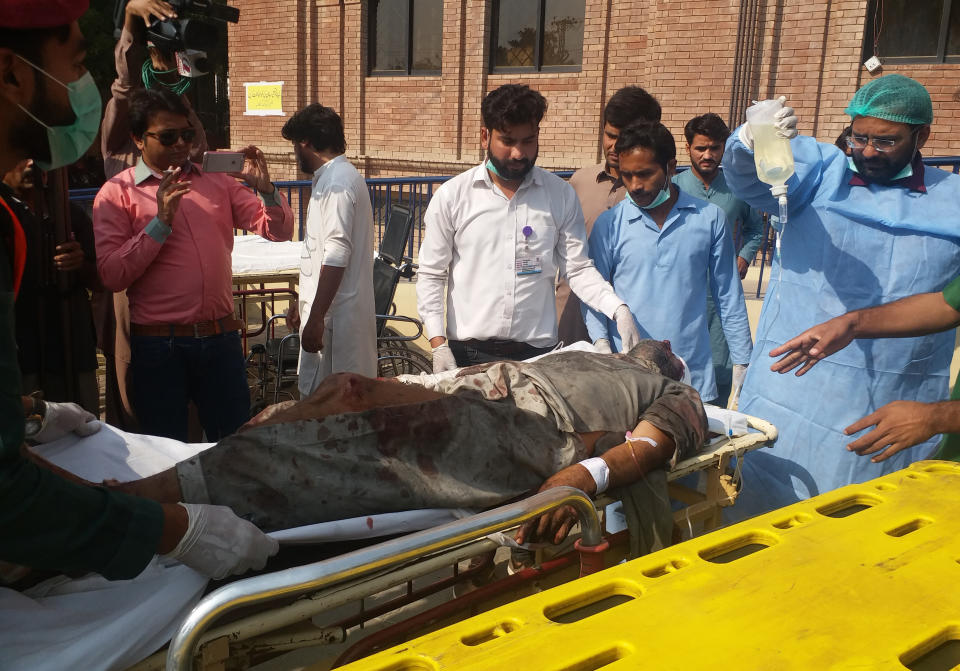 Hospital staff take care of a person who was injured in a train fire, on his arrival at a hospital in Multan, Pakistan, Thursday, Oct. 31, 2019. A massive fire engulfed three carriages of the train traveling in the country's eastern Punjab province (AP Photo/Asim Tanveer)