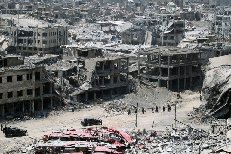 A picture taken on July 9, 2017, shows Iraqi forces walking amidst the destruction in Mosul's Old City