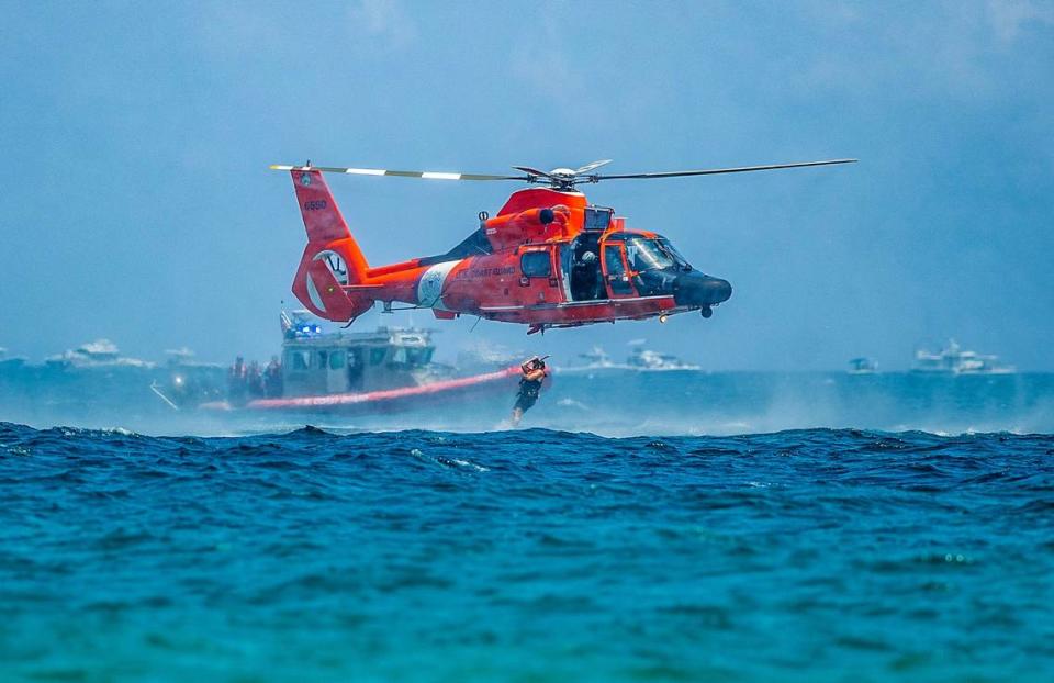 A rescue swimmer jumps to the water from a U.S Coast Guard Helicopter next to a vessel as they perform a search and rescue demonstration during the 2023 Fort Lauderdale Air Show on Saturday, April 29, 2023.