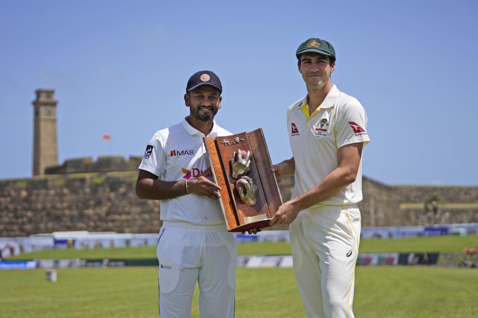 Sri Lanka's cricket captain Dimuth Karunaratne, left, and his Australian counterpart Pat Cummins pose for photographers holding the Warne-Muralitharan Trophy ahead of their first test cricket match in Galle, Sri Lanka, Tuesday, June 28, 2022. (AP Photo/Eranga Jayawardena)