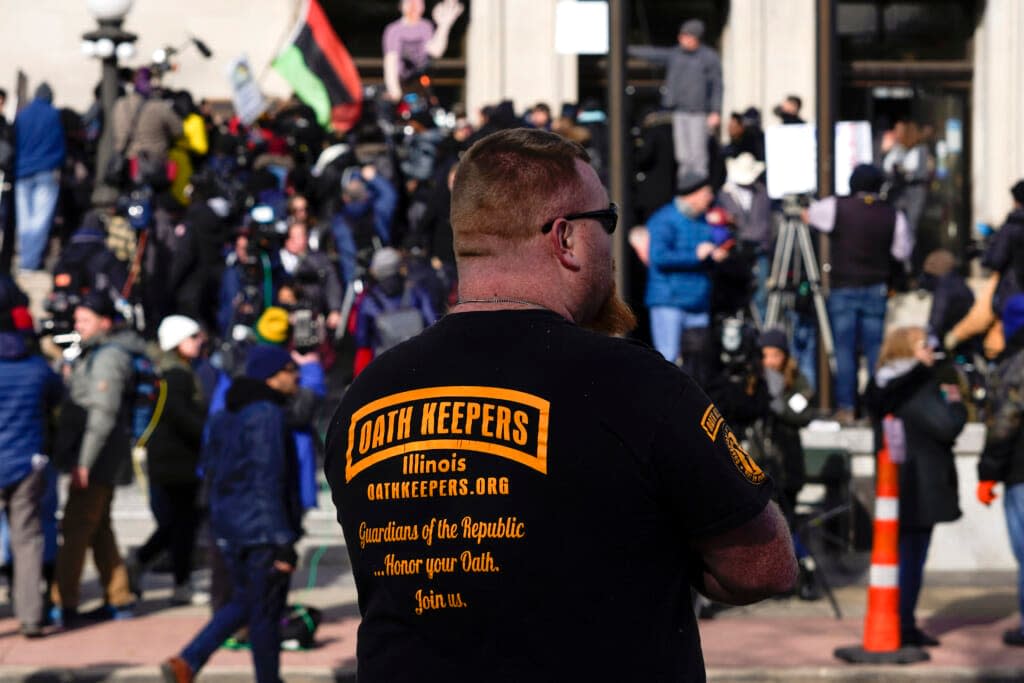 A man wearing an Oath Keepers shirt stands outside the Kenosha County Courthouse, Nov. 19, 2021 in Kenosha, Wis. (AP Photo/Paul Sancya, File)