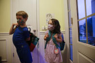 Siblings Paul Adamus, 7, left, and Neva Adamus, 5, put on their backpacks to get ready for their first day of school on Monday, Aug. 3, 2020, in Dallas, Ga. Neighboring states arrived at differing conclusions on who’s in charge of the reopening of schools. The differences in philosophy underscore some of the difficulties facing states as they grapple with how to proceed amid growing coronavirus infections in numerous states. (AP Photo/Brynn Anderson)