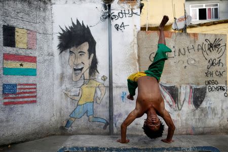 A member of the Acorda Capoeira (Awaken Capoeira) group prepares for a performance for tourists in the Rocinha favela in Rio de Janeiro, Brazil, July 25, 2016. REUTERS/Bruno Kelly