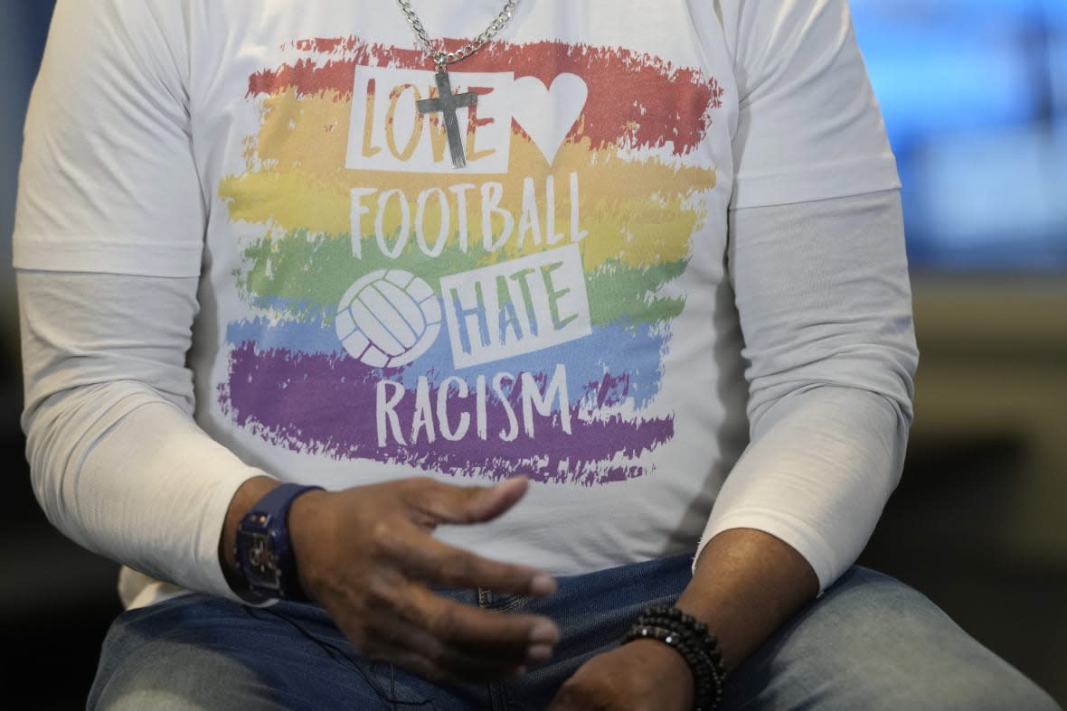 A close-up of the anti-racism message on the t-shirt of former Chelsea soccer player Paul Canoville during an interview with the Associated Press at Chelsea’s Stamford Bridge ground in London, Thursday, March 2, 2023. The manifestation of a deeper societal problem, racism is a decades-old issue in soccer — predominantly in Europe but seen all around the world — that has been amplified by the reach of social media and a growing willingness for people to call it out. (AP Photo/Alastair Grant)