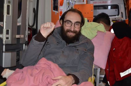 Semih Ozakca, a 28-year-old Turkish teacher who has been on hunger strike for months to protest about losing his job in the government's purge since a failed coup attempt last year and released from jail pending his trial on terrorism-related charges, gestures as he leaves an ambulance upon his arrival at his home in Ankara, Turkey, October 20, 2017. Picture taken October 20, 2017. Depo Photos via REUTERS