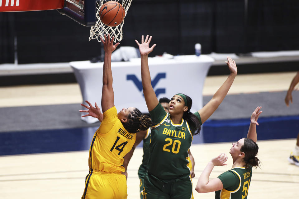 West Virginia forward Kari Niblack (14) shoots while defended by Baylor center Hannah Gusters (20) and forward Caitlin Bickle (51) during the first half of an NCAA college basketball game Thursday, Dec. 10, 2020, in Morgantown, W.Va. (AP Photo/Kathleen Batten)