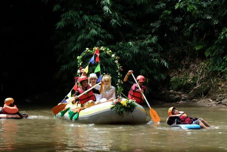 Novanto Rahman and his bride Sandra Fidelia Novianti, a volunteer who takes part in a Ciliwung river clean-up initiative, hold part of their wedding ceremony on the Ciliwung, which runs more than 100 km (60 miles) from its source in West Java to Jakarta bay, in Depok south of Jakarta, Indonesia December 18, 2016. Picture taken December 18, 2016. REUTERS/Adi Kurniawan