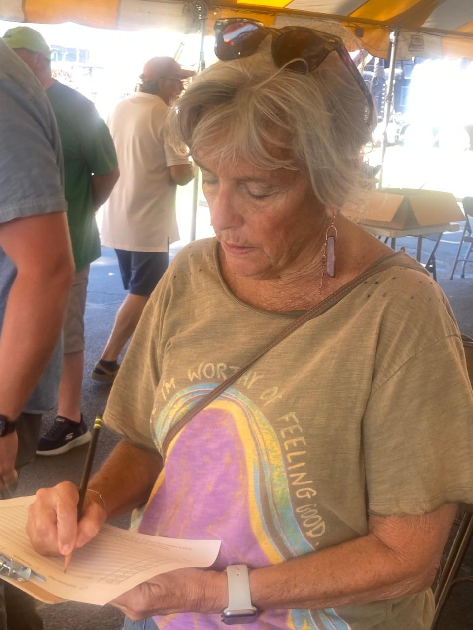 Lindsey Helm of Springfield, one of the judges at the Illinois State Fair Chili Cookoff, makes some notes outside of The Shed Sunday.