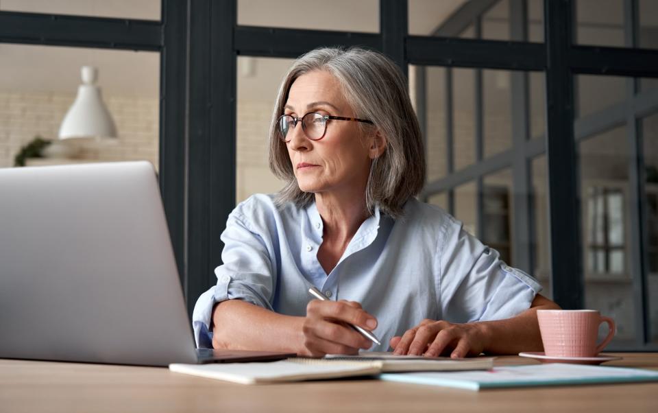 Mature woman working on her laptop - insta_photos/iStockphoto