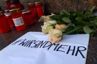 Candles and flowers are seen placed at the Brothers Grimm monument for the victims of a shooting in Hanau