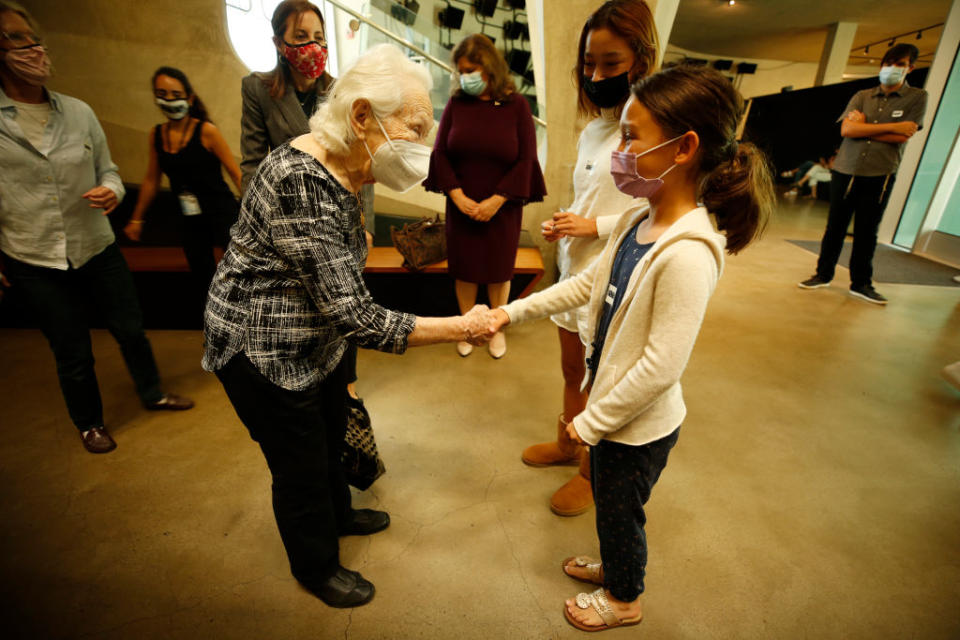 LOS ANGELES, CA - JULY 29:                                                         
97-year-old Holocaust survivor Renee Firestone -- one of the oldest remaining such survivors in the world is is treated like a rock star as she greets sisters Rainey, 13, and Kensi, 10, Renwick, who where visiting the museum with their Father Ed Renwick for a advanced preview of the Museum for students. The Holocaust Museum LA is reopening this weekend with a new permanent installation, USC Shoah Foundations Dimensions in Testimony, which gives visitors the opportunity to have a virtual one-on-one conversation with Renee as a Holocaust survivor. The pioneering project integrates advanced filming techniques, specialized display technologies and next-generation natural language processing to create an interactive biography so there viewer can receive real-time responses to questions from pre-recorded video images. Our museum was founded by survivors who wanted to share their stories publicly and educate the next generation, said Beth Kean, CEO of the Museum. With Dimensions in Testimony, countless future generations of visitors and students can hear those stories from the survivors and learn directly from those who were there, even when they are no longer with us.    Holocaust Museum on Thursday, July 29, 2021 in Los Angeles, CA. (Al Seib / Los Angeles Times via Getty Images).