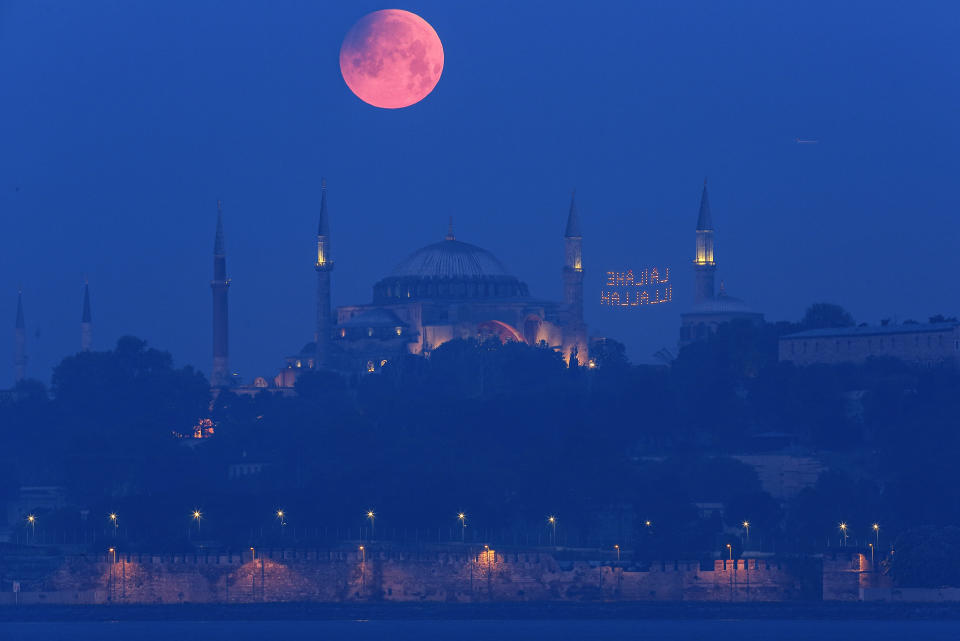 A full moon rises above the iconic Haghia Sophia in Istanbul, Turkey, early Monday, May 16, 2022. (AP Photo/Mucahid Yapici)