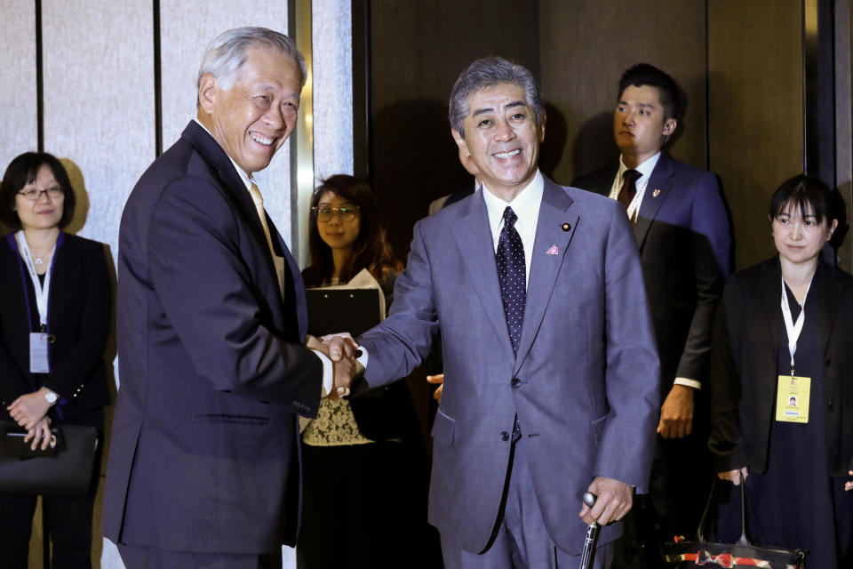 Singapore's Defense Minister Ng Eng Hen greets Japan's Defense Ministe Takeshi Iwaya during the ASEAN and Japanese Defense Ministers' Informal Meeting at the 12th ASEAN Defense Ministers' Meeting in Singapore on Saturday, Oct. 20, 2018. (AP Photo/Don Wong)