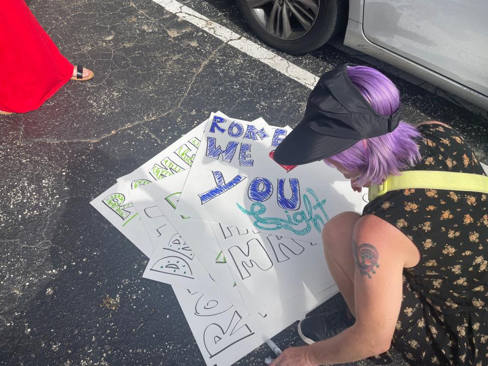 Lindsey Milles makes signs at a vigil for Romen Phelps on Saturday in West Palm Beach. Milles was in school with Phelps at Dreyfoos School of the Arts and remembers him as someone who had "the ability to let people shine by using his skills."