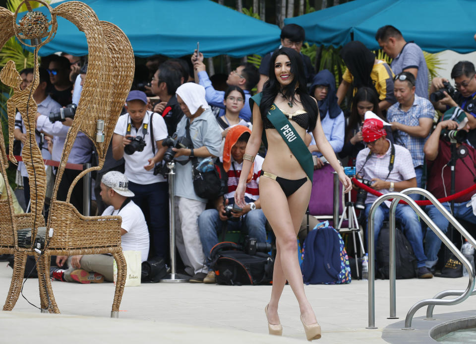 In this Oct. 11, 2018 photo, Venezuelan born Jessica Russo, representing Peru in the Miss Earth 2018 beauty pageant, parades during the media presentation in the Miss Earth 2018 Beauty pageant in Manila, Philippines. As masses of Venezuelans flee their country's economic implosion, dozens of beauty queens from that country are also making a new life for themselves abroad, and using their legendary prowess on the catwalk to represent their adopted homelands. (AP Photo/Bullit Marquez)