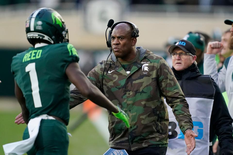 Michigan State head coach Mel Tucker greets wide receiver Jayden Reed (1) after a touchdown during the first half of an NCAA college football game against Maryland, Saturday, Nov. 13, 2021, in East Lansing, Mich. (AP Photo/Carlos Osorio)