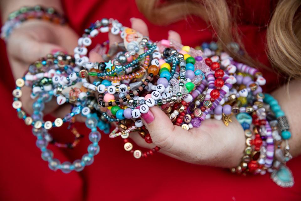 Emily Schenk, 30, of Milford, shows off the bracelets that she and her friends made with Taylor Swift's lyric at Central Park in Milford on Tuesday, June 6, 2023.