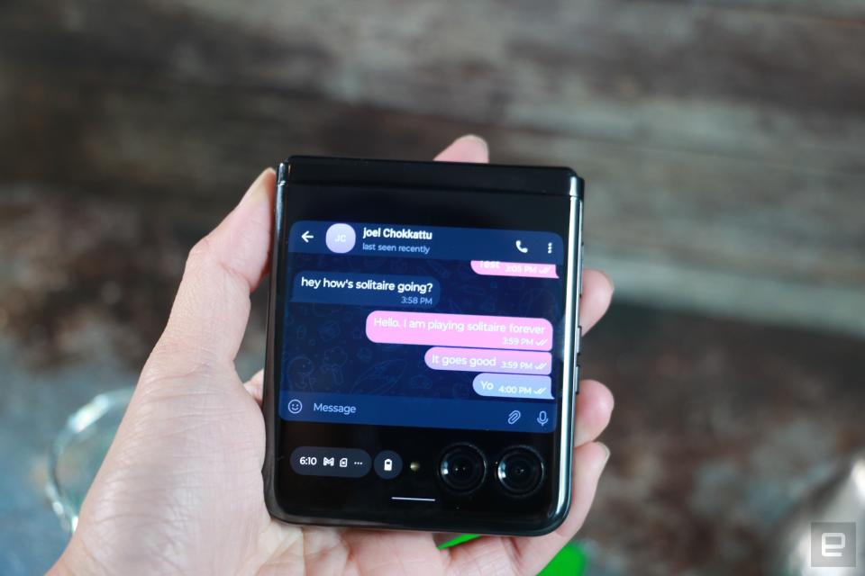 <p>The Motorola Razr+ folded shut and held in mid-air, with a Telegram chat showing on its external display.</p> 