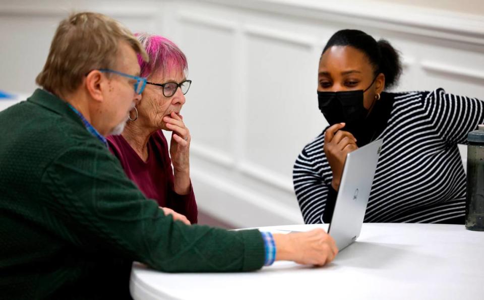 Sammy Surface, left, and his wife Shelagh Boughton, center, work with navigator Shay Hinton during a Wake County ACA and Medicaid enrollment event at Martin Street Baptist Church in Raleigh, N.C., Friday, Dec. 1, 2023. Ethan Hyman/ehyman@newsobserver.com