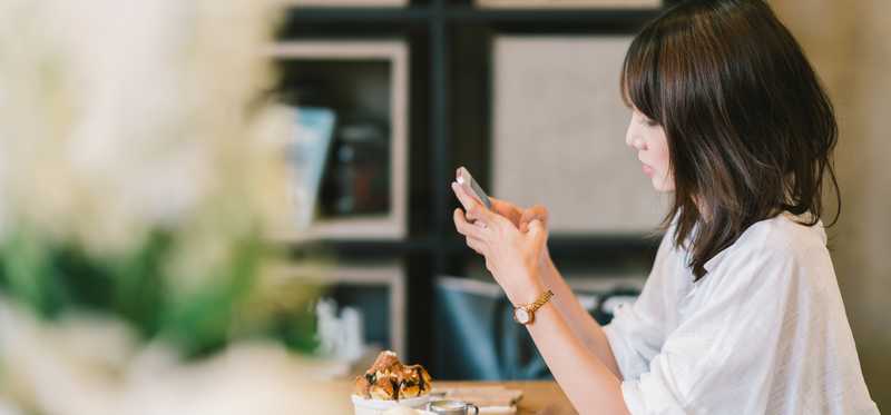 Girl using a smartphone in a cafe.