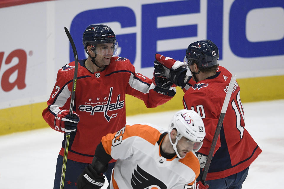 Washington Capitals left wing Conor Sheary (73) celebrates his goal with right wing Daniel Sprong (10) during the first period of an NHL hockey game, next to Philadelphia Flyers defenseman Shayne Gostisbehere (53), Tuesday, April 13, 2021, in Washington. (AP Photo/Nick Wass)