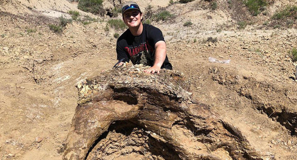 Harrison Duran with the partial skull of a 65-million-year-old triceratops fossil.