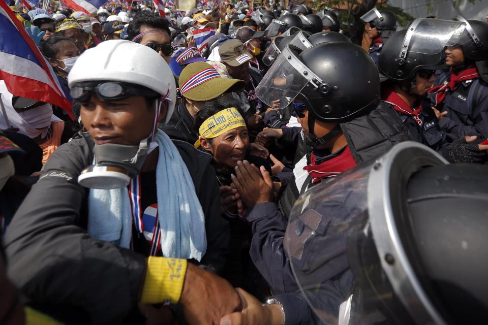 Policemen and anti-government protesters greet each other inside the compound of the metropolitan police headquarters, the site of fierce clashes over the last few days, in Bangkok December 3, 2013. Thailand's government ordered police to stand down and allow protesters into state buildings on Tuesday, removing a flashpoint for clashes and effectively bringing an end to days of violence in Bangkok in which five people have died. REUTERS/Damir Sagolj (THAILAND - Tags: POLITICS CIVIL UNREST)