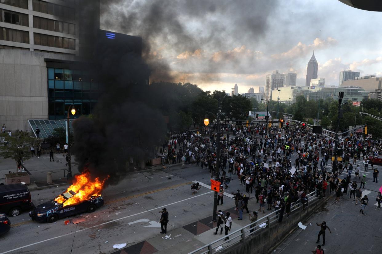 A police car burns in Atlanta during a protest over the death of George Floyd: REUTERS