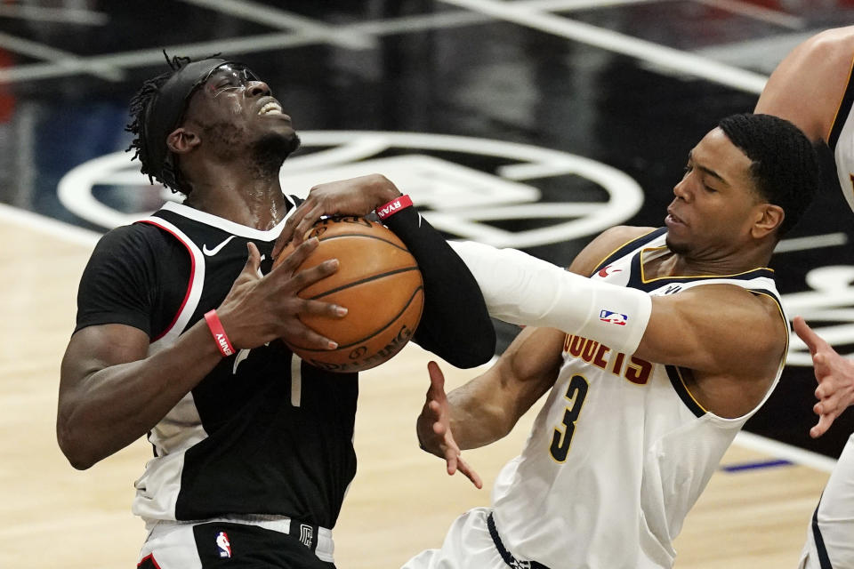 Los Angeles Clippers guard Reggie Jackson, left, has his shot blocked by Denver Nuggets guard Shaquille Harrison during the second half of an NBA basketball game Saturday, May 1, 2021, in Los Angeles. (AP Photo/Mark J. Terrill)
