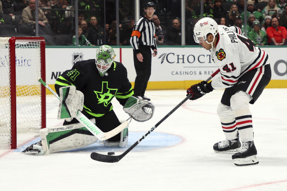 Dallas Stars goaltender Scott Wedgewood (41) defends as Chicago Blackhawks defenseman Isaak Phillips (41) takes a shot in the second period of an NHL hockey game, Sunday, Dec. 31, 2023, in Dallas. (AP Photo/Richard W. Rodriguez)