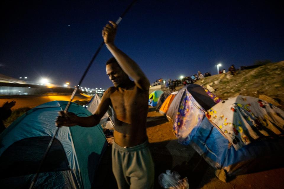 Venezuelan migrants set up an encampment on the south bank of the Rio Grande in Ciudad Juarez. Many of the migrants have been expelled under Title 42 after seeking asylum and are hoping to be accepted as refugees in the U.S. In this photo a man prepares a tent. 